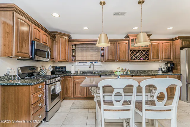 a large kitchen with granite countertop a sink a stove a oven a counter space and cabinets