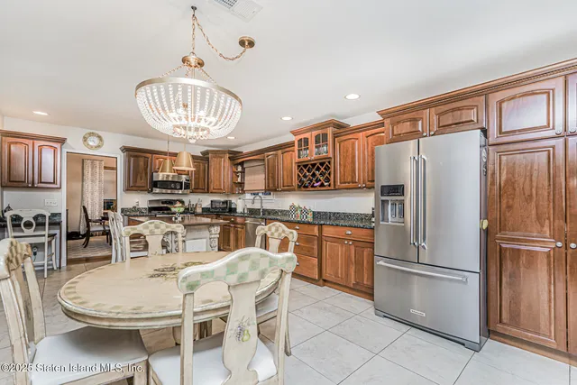 a kitchen with stainless steel appliances a dining table chairs and chandelier