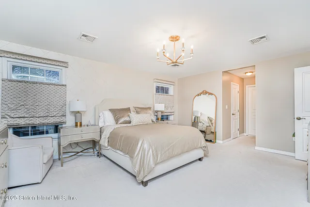 a spacious bedroom with a bed and a flat screen tv