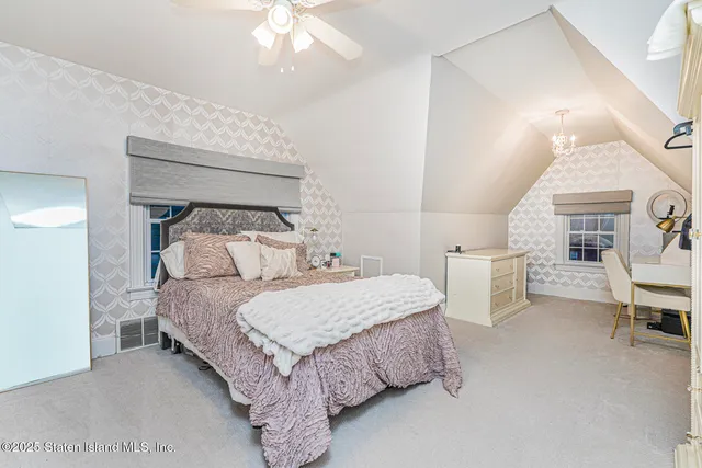 a view of a roof deck with table and chairs couches and a barbeque with wooden fence and floor