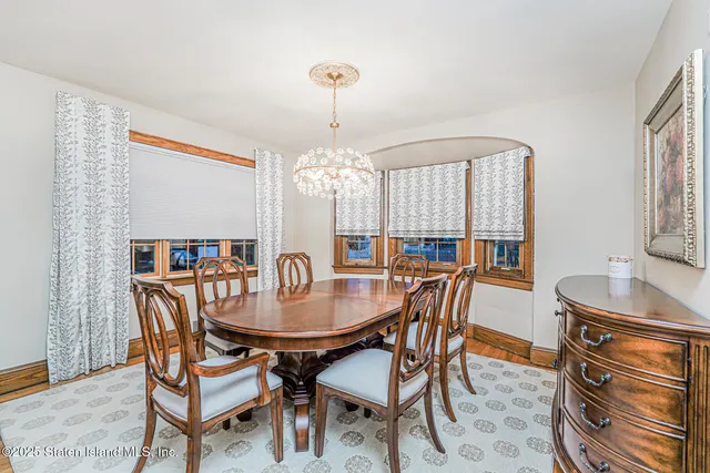 a dining room with furniture a chandelier and wooden floor