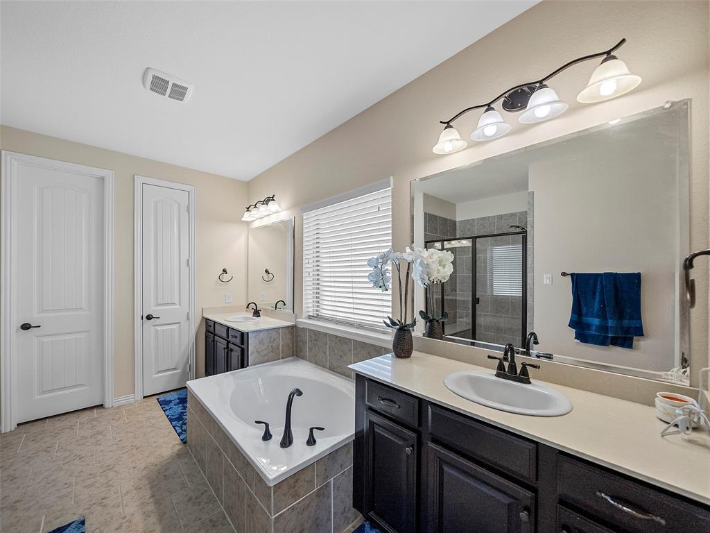 5207 Seth Avenue Sachse, TX 75048 - Photo 16 of 28 Bathroom with two vanities, a garden tub, a shower stall, and tile patterned floors