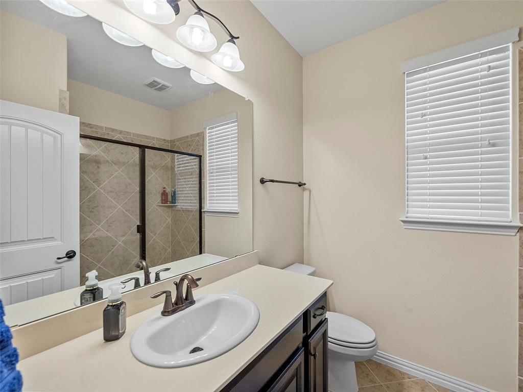 5207 Seth Avenue Sachse, TX 75048 - Photo 25 of 28 Full bathroom with toilet, a shower stall, vanity, tile patterned flooring, and baseboards