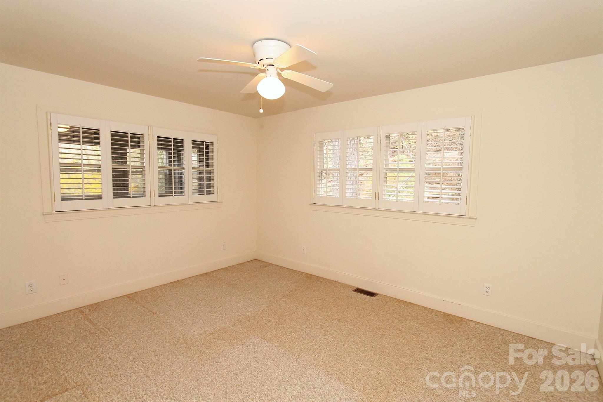 407 Turley Falls Road Hendersonville, NC 28739 - Photo 14 of 28 an empty room with wooden floor and windows