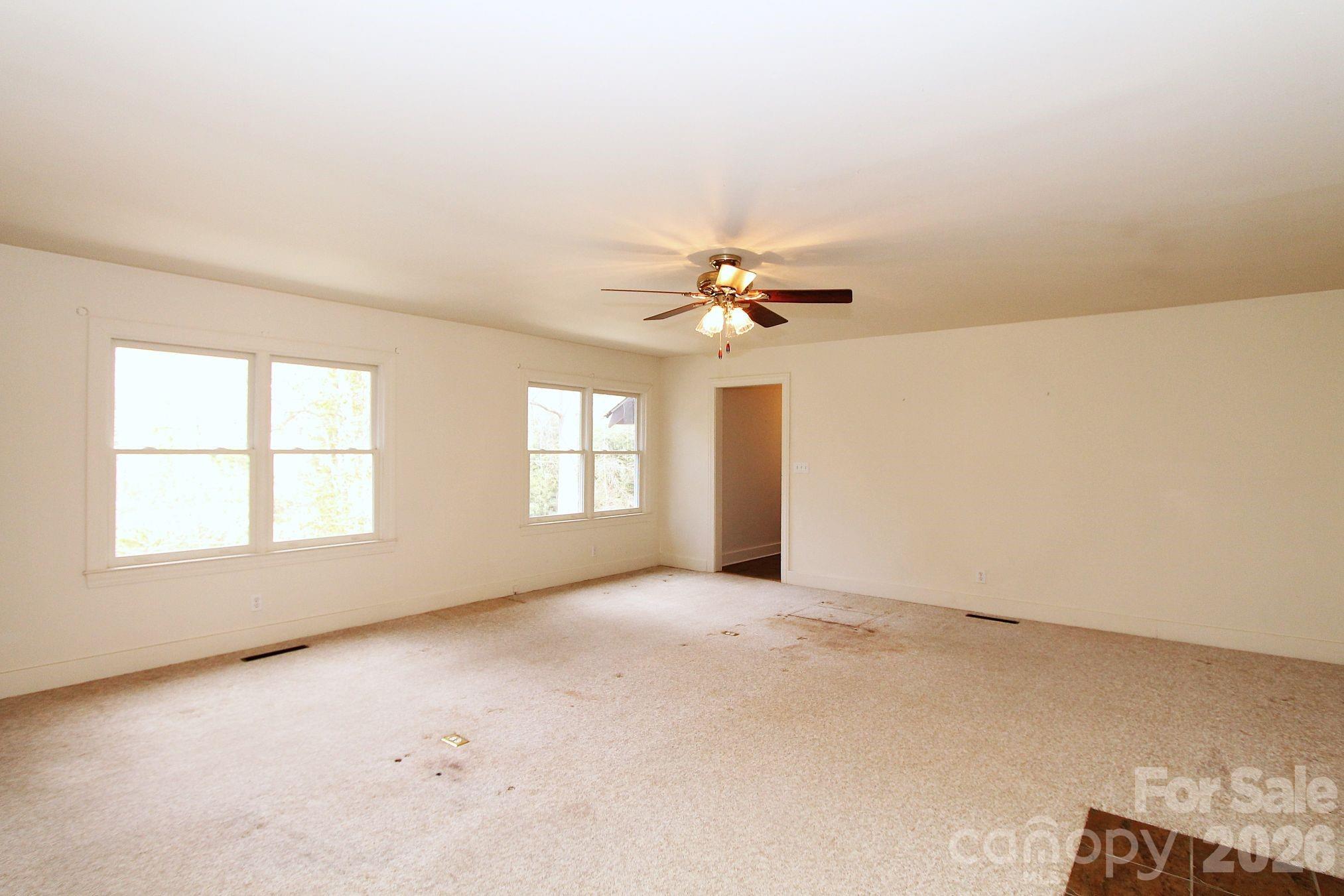 407 Turley Falls Road Hendersonville, NC 28739 - Photo 7 of 28 an empty room with windows and chandelier fan