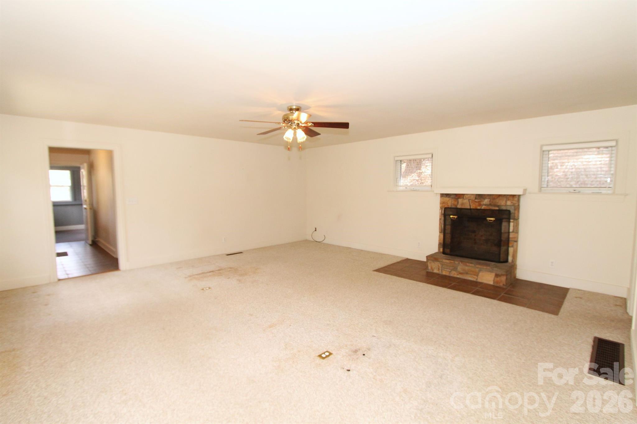 407 Turley Falls Road Hendersonville, NC 28739 - Photo 8 of 28 wooden floor in an empty room with a fireplace