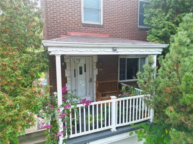 a view of a house with a small yard and a fountain