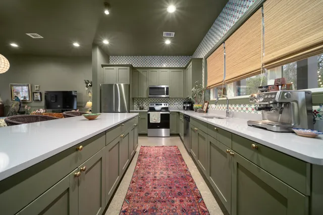 a large kitchen with stainless steel appliances lots of counter space and a sink