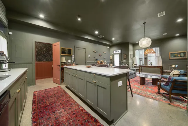 a kitchen with kitchen island a sink stainless steel appliances and cabinets