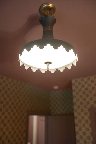 a bed room with a bed mirror and a flat tv screen on dresser