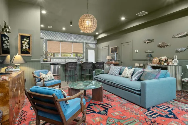 a living room with furniture chandelier and a large window