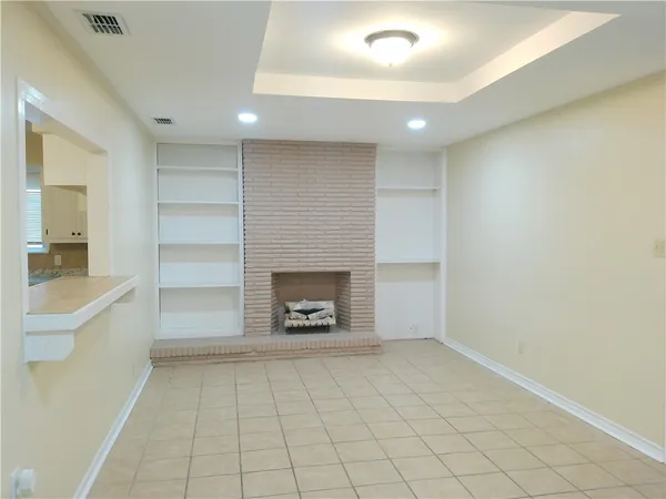 an empty room with a fireplace and cabinet