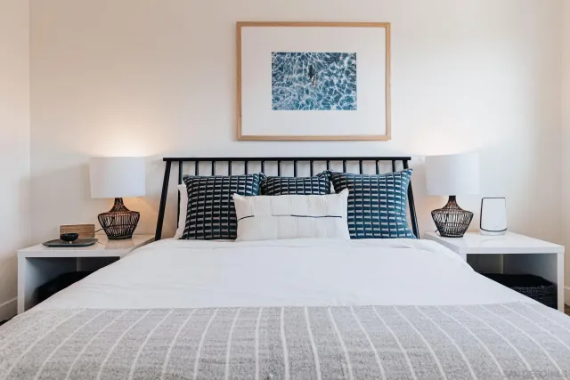 a bedroom with a bed and a flat tv screen on dresser