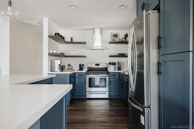 a kitchen with stainless steel appliances granite countertop a table chairs sink and cabinets