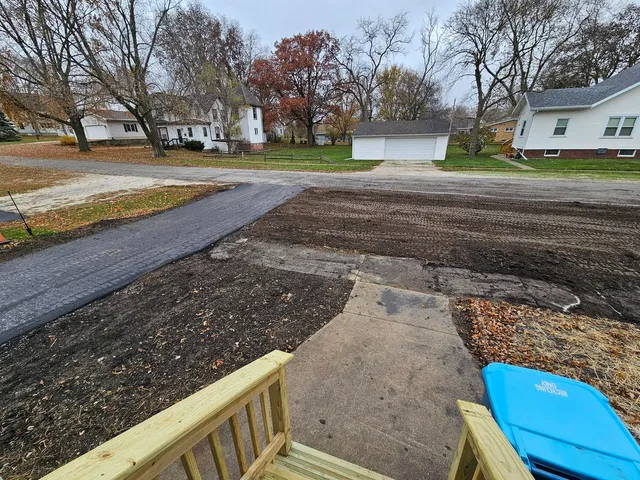 a view of a house with a yard covered the side of the road