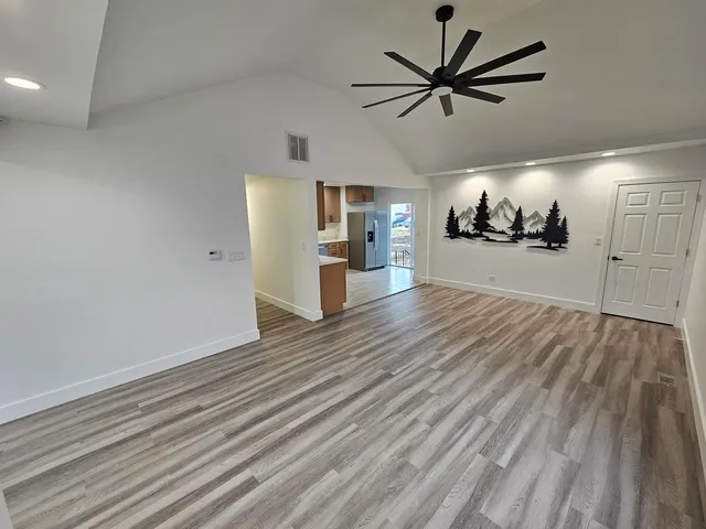 a view of a living room and kitchen with furniture wooden floor and windows