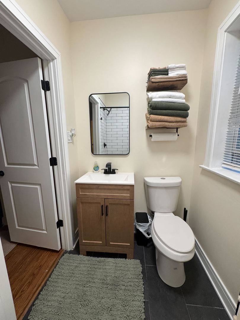 610 East 74th Street, Unit 1B Chicago, IL 60619 - Photo 11 of 15 a bathroom with a toilet sink and mirror