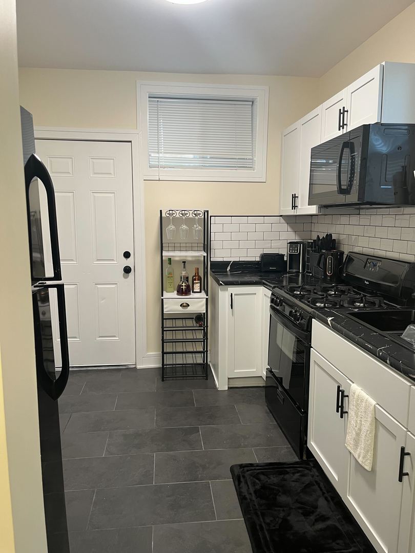 610 East 74th Street, Unit 1B Chicago, IL 60619 - Photo 15 of 15 a kitchen with a refrigerator and a sink