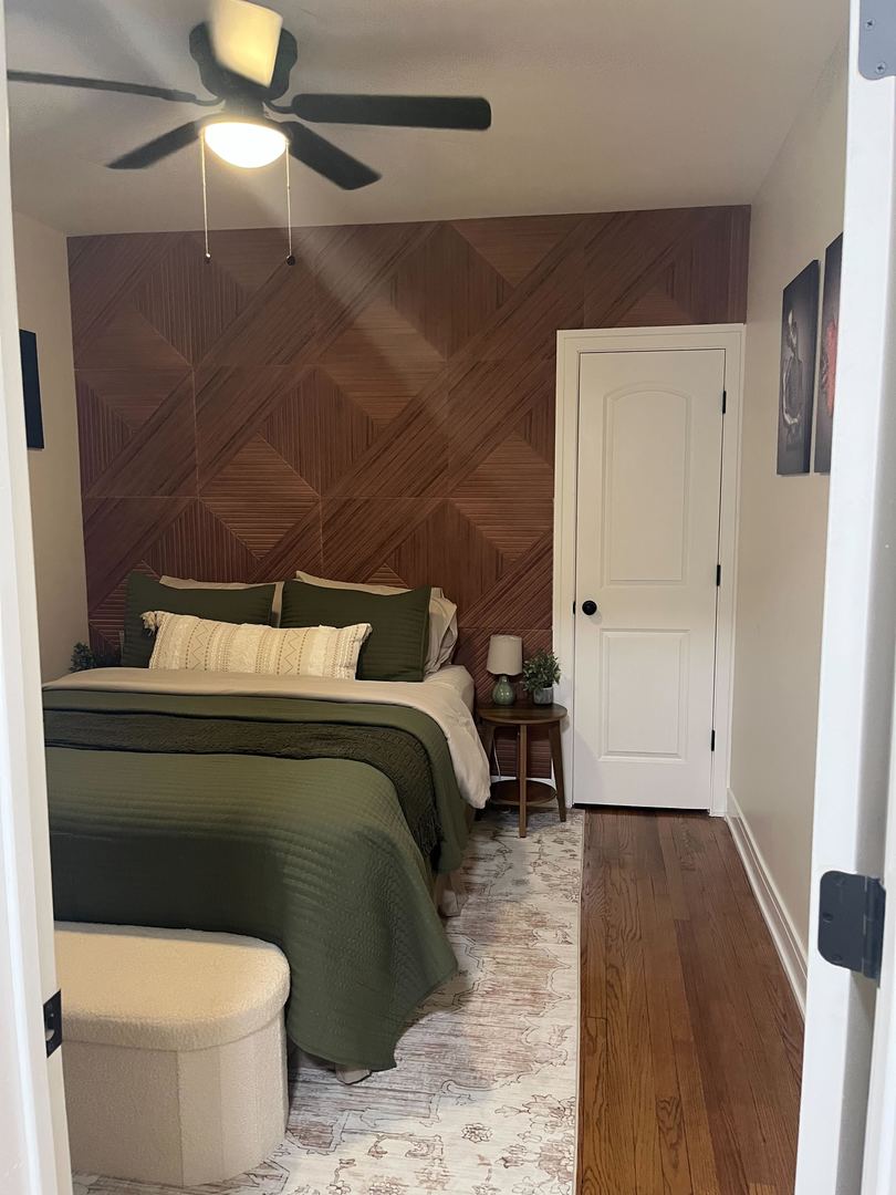 610 East 74th Street, Unit 1B Chicago, IL 60619 - Photo 10 of 15 a bedroom with a bed and a chandelier