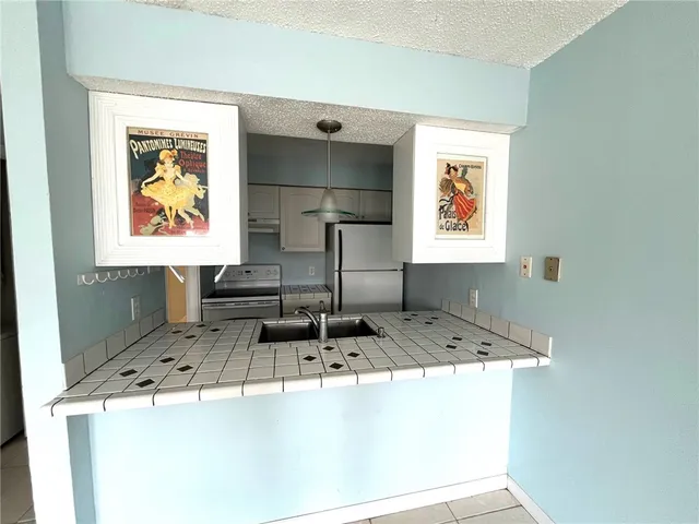 a kitchen with kitchen island sink and large window