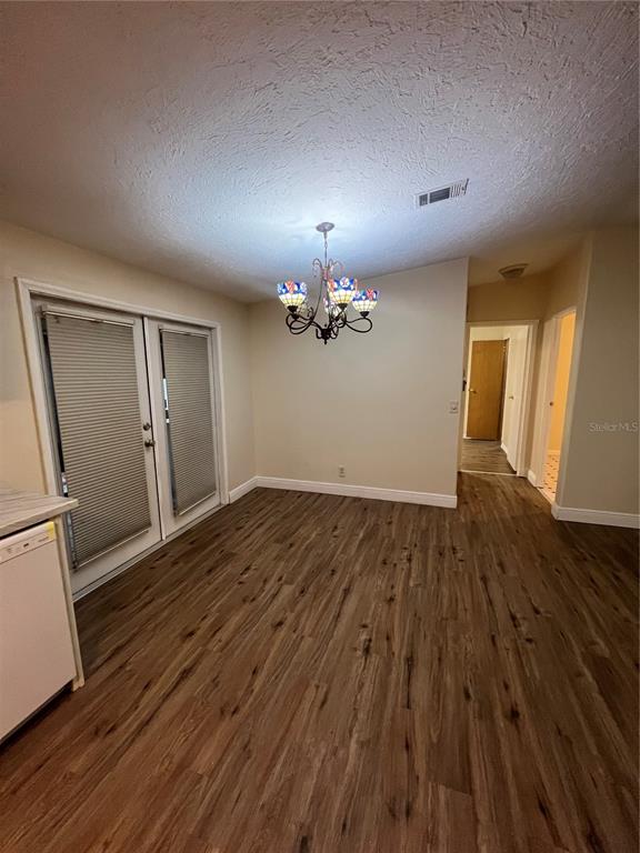 2833 Southeast 18th Terrace Okeechobee, FL 34974 - Photo 12 of 34 a view of an empty room with wooden floor and a kitchen