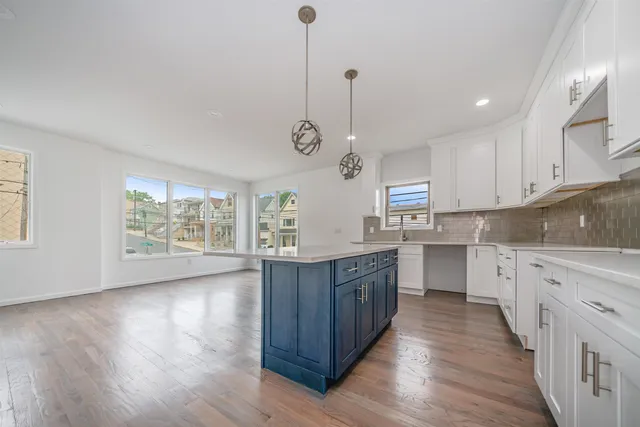 a kitchen with stainless steel appliances granite countertop wooden floors sink and cabinets