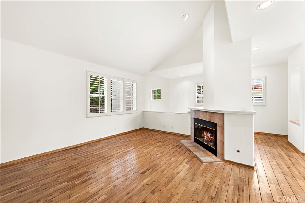 Undisclosed Address Newport Coast, CA 92657 - Photo 2 of 26 an empty room with wooden floor a fireplace and windows