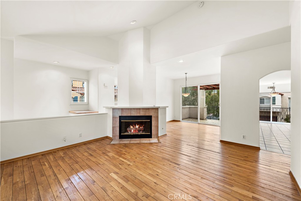 Undisclosed Address Newport Coast, CA 92657 - Photo 3 of 26 an empty room with wooden floor fireplace and windows
