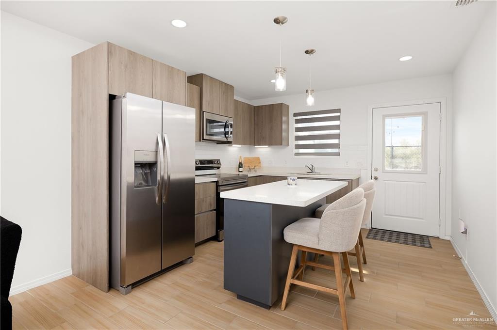 1527 West B Street Mission, TX 78572 - Photo 5 of 17 a kitchen with stainless steel appliances granite countertop a refrigerator a sink a stove a dining table and chairs