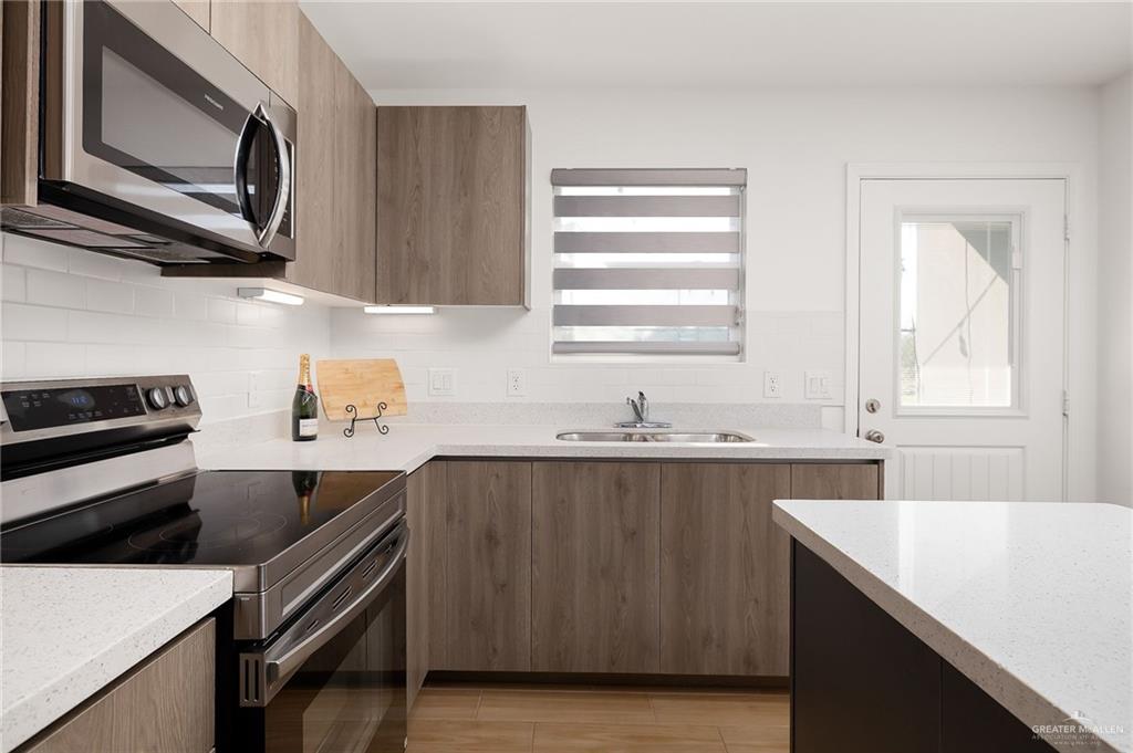 1527 West B Street Mission, TX 78572 - Photo 7 of 17 a kitchen with a sink stove top oven and cabinets