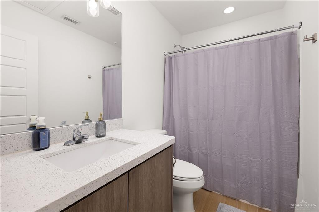1527 West B Street Mission, TX 78572 - Photo 9 of 17 a bathroom with a sink a toilet and shower curtain