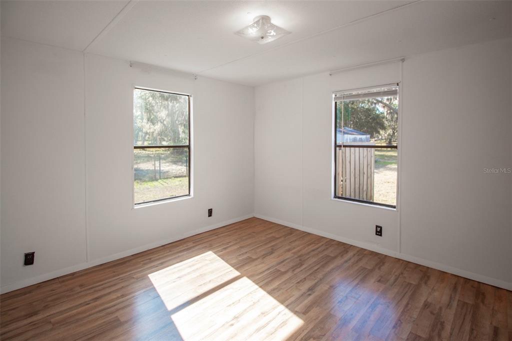 11 Sycamore Street Flagler Beach, FL 32136 - Photo 9 of 21 an empty room with wooden floor and windows