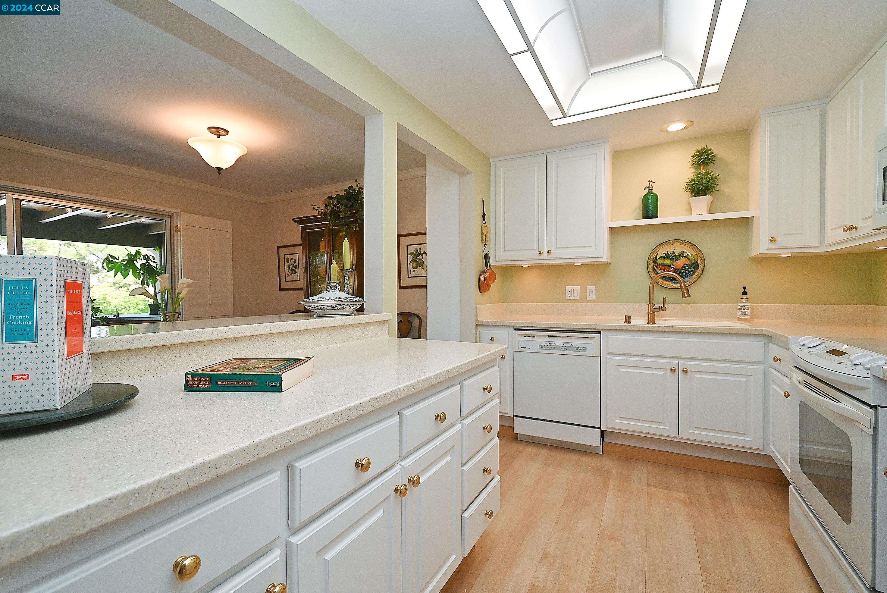 1348 Running Springs Road, Unit 3 Walnut Creek, CA 94595 - Photo 1 of 1 a kitchen with kitchen island white cabinets and white appliances
