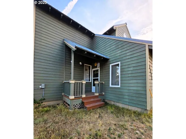 a backyard of a house with table and chairs