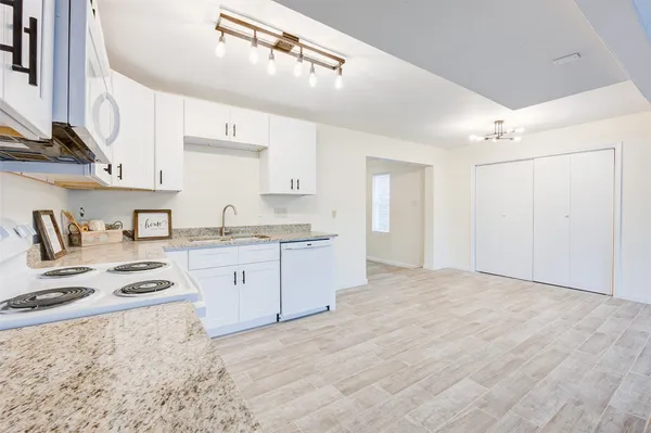 a kitchen with granite countertop a sink stove and cabinets