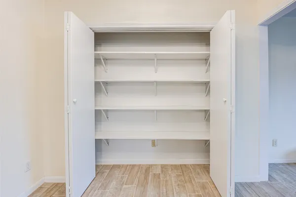 a view of walk in closet with empty racks