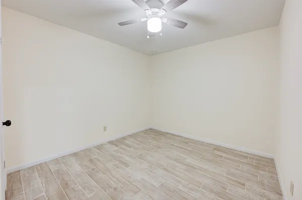 a view of an empty room with chandelier fan