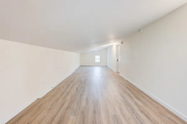 a view of a room with wooden floor and white walls