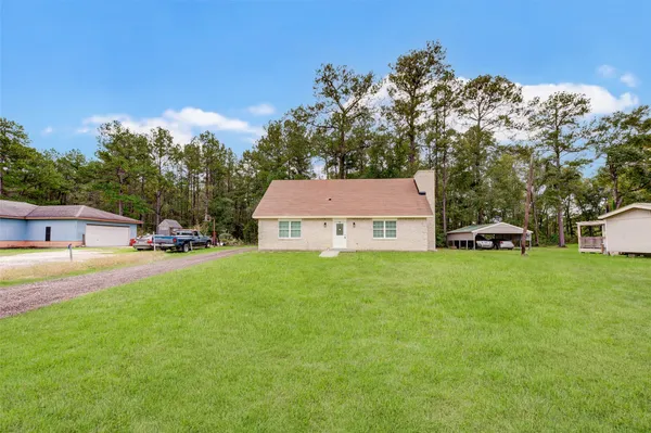 a view of a house with a yard and sitting area