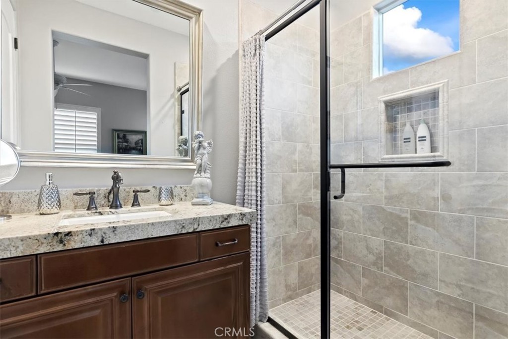 81094 Monarchos Circle La Quinta, CA 92253 - Photo 42 of 75 a bathroom with a granite countertop sink a mirror and a shower