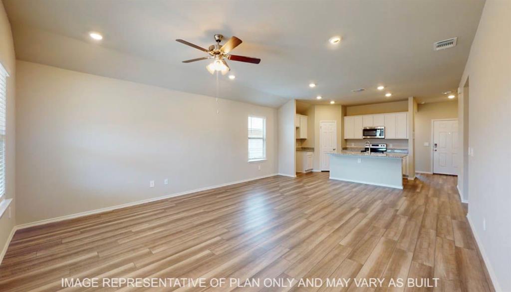 10312 Neptune Court Waco, TX 76708 - Photo 3 of 9 a view of an empty room and kitchen with wooden floor