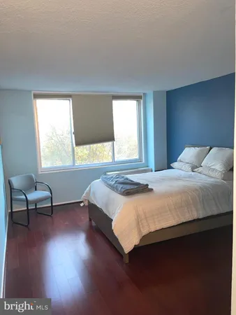 a bedroom with a bed a chair and a window