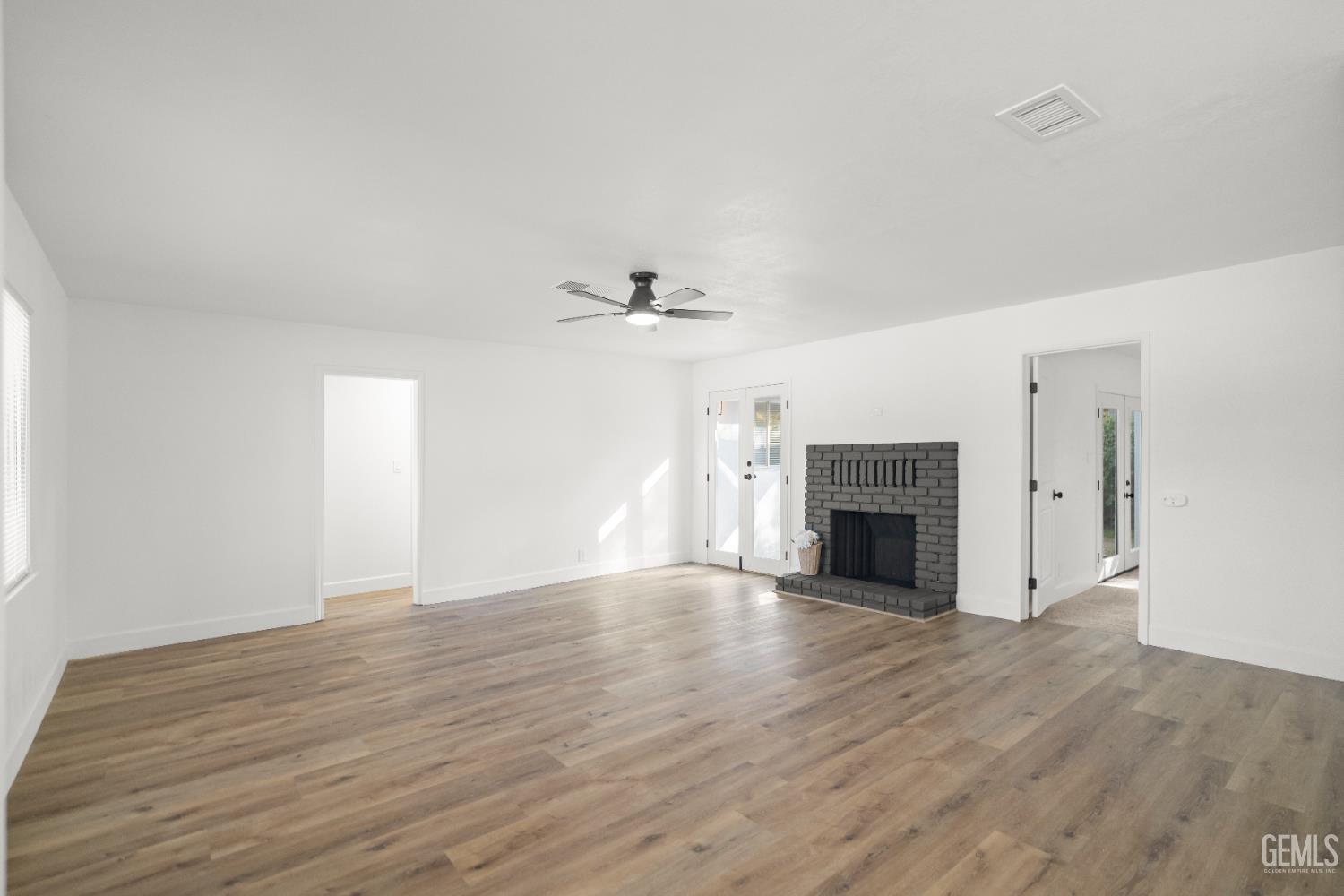 Undisclosed Address Tehachapi, CA 93561 - Photo 13 of 49 a view of empty room with wooden floor and fireplace