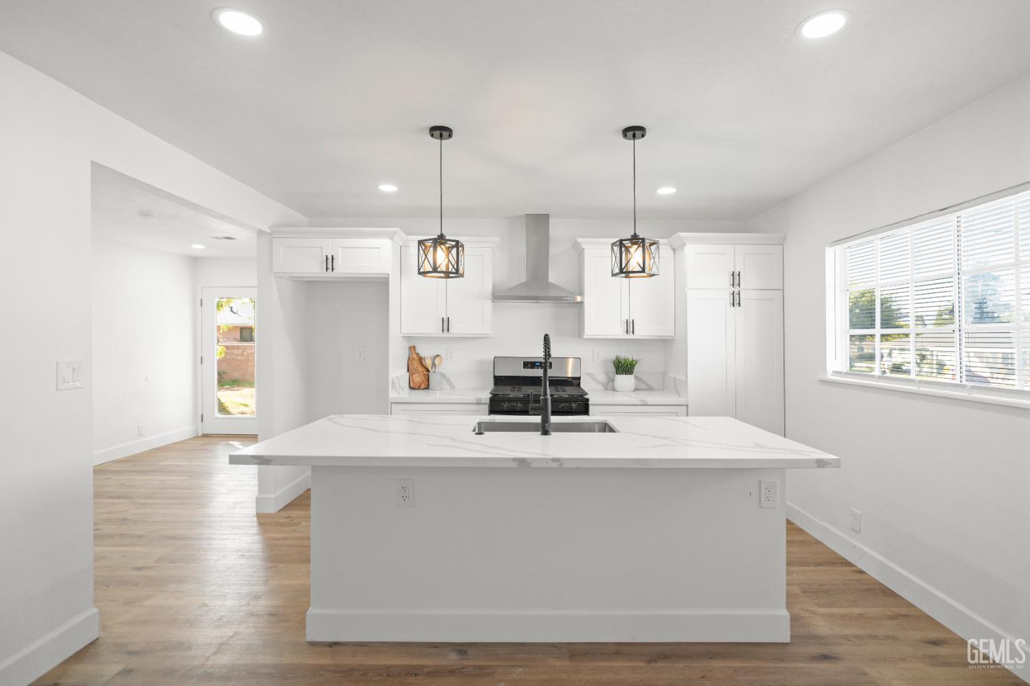 Undisclosed Address Tehachapi, CA 93561 - Photo 14 of 49 a large kitchen with kitchen island a stove a sink a center island and wooden floor