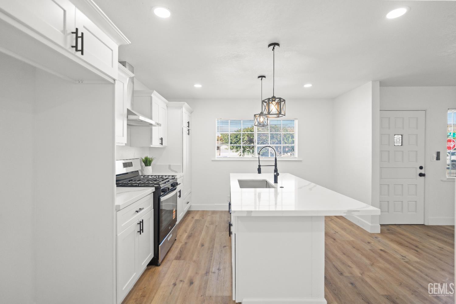 Undisclosed Address Tehachapi, CA 93561 - Photo 20 of 49 a kitchen with kitchen island granite countertop a sink stove and wooden floor