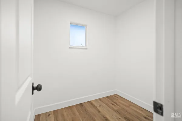 a view of a room with wooden floor and a window