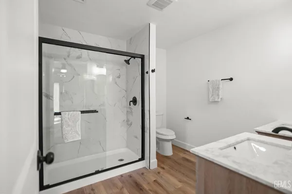 a bathroom with a granite countertop sink toilet and shower