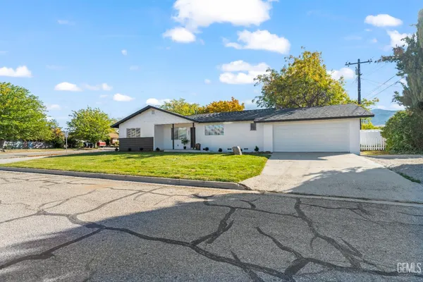 a view of a house with a big yard and large trees
