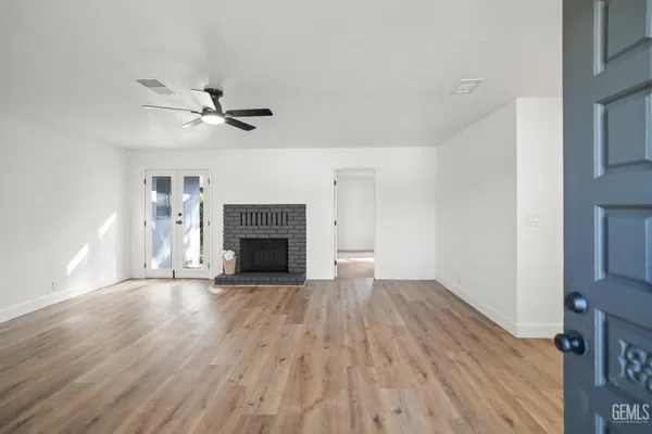 a view of empty room with wooden floor and fireplace