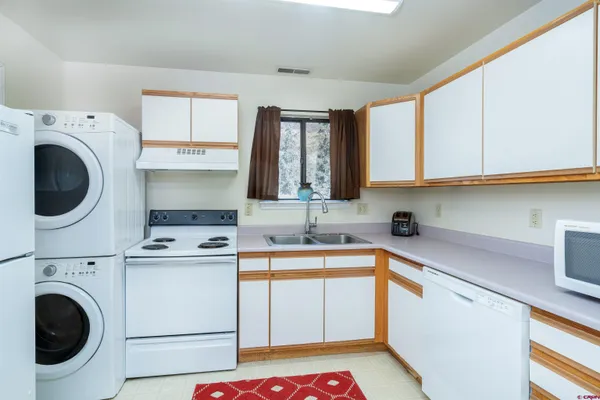 a utility room with sink dryer and washer